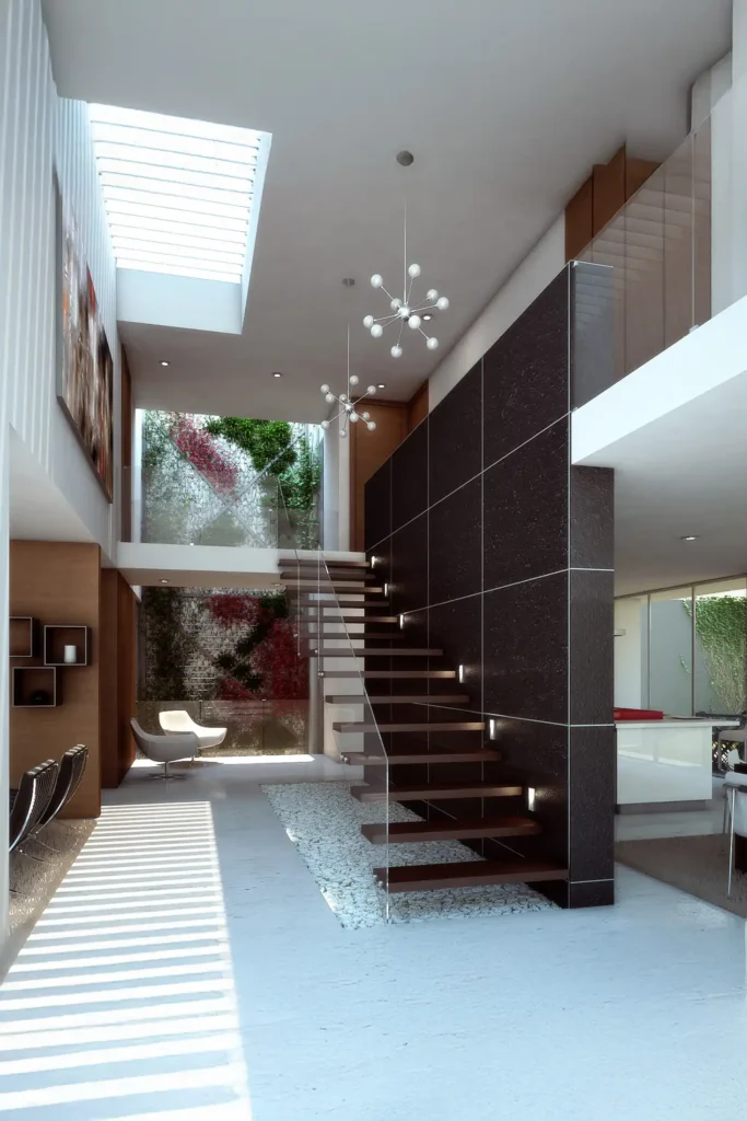 Diseño a medida de una residencia de lujo por nuestra firma de arquitectura, destacando una escalera flotante, un tragaluz y un muro de piedra oscura.